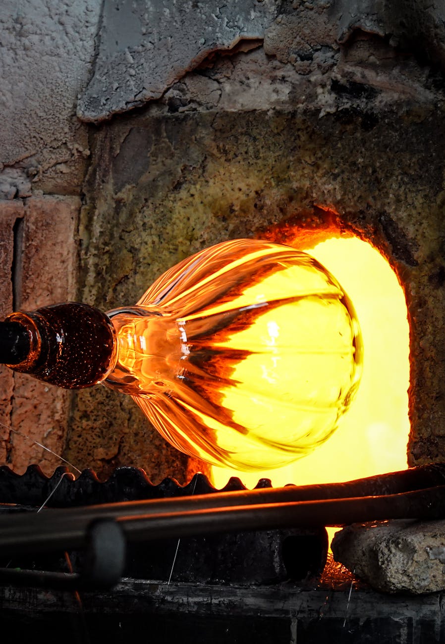 Molten glass being shaped at the opening of a furnace during glassblowing