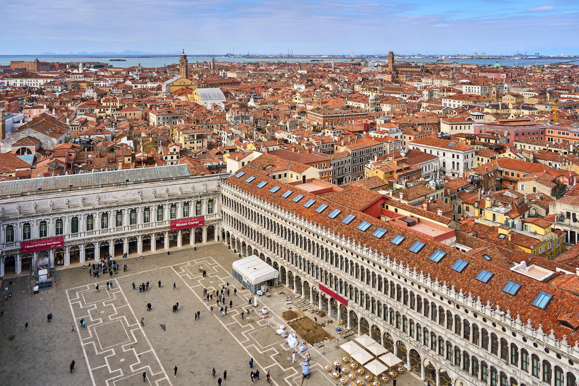 Aerial view of Venice city with red-roofed buildings, Museo Correr, and the waterfront in the background