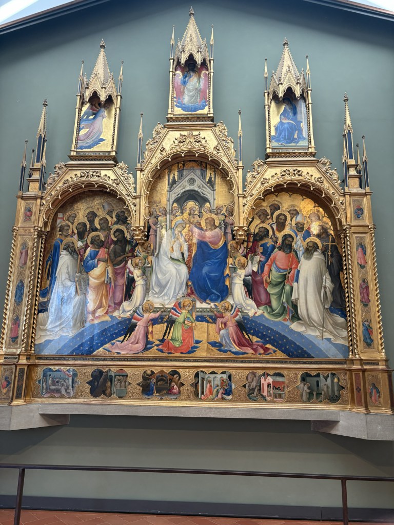 Altarpiece depicting religious figures in vibrant colors and intricate gold detailing, featuring angels, saints, and scenes from biblical stories.